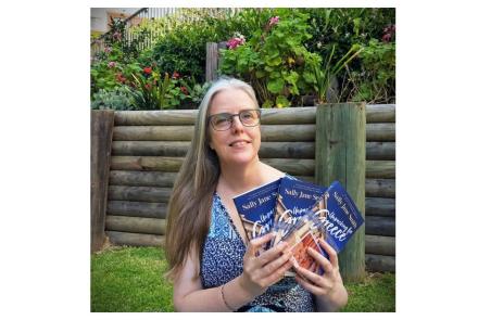 The author holding three copies of her book