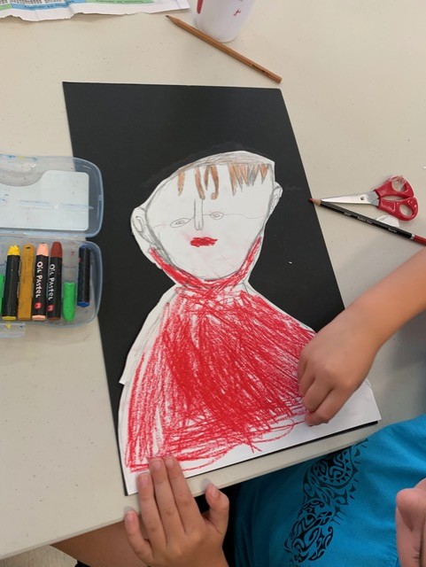 Black background with drawn portrait stuck on top, coloured red.