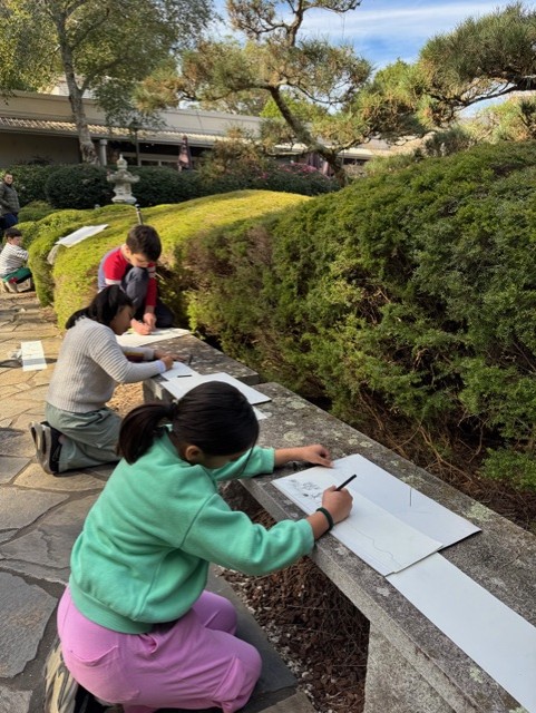 Children drawing on paper in the Japanese Gardens.