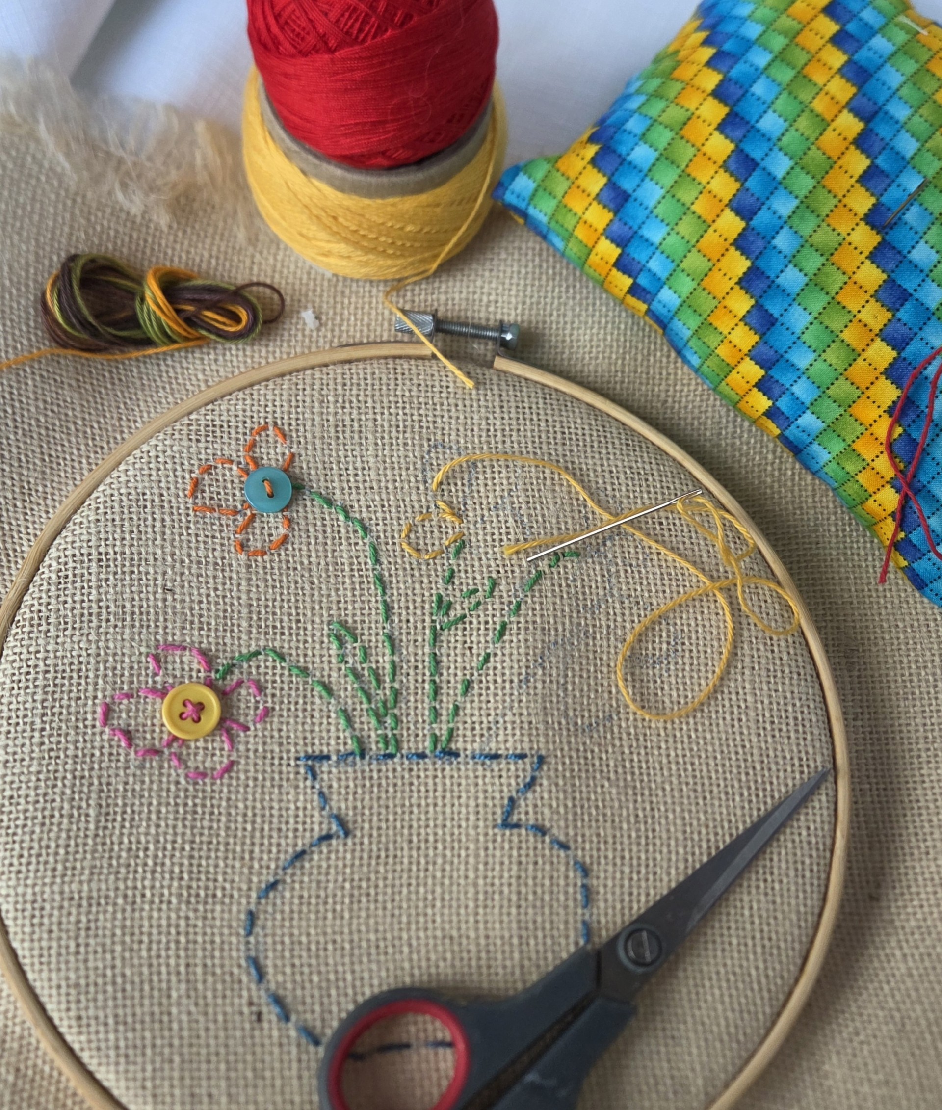 Embroidered vase and flowers done on an embroidery hoop.