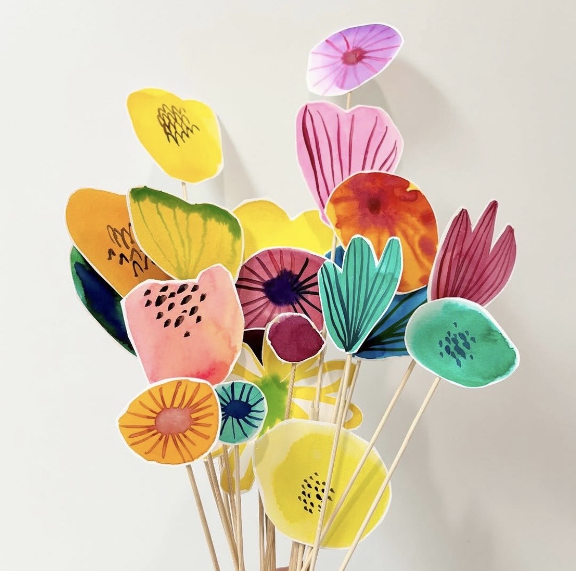 Multiple bright coloured flowers, all on sticks.