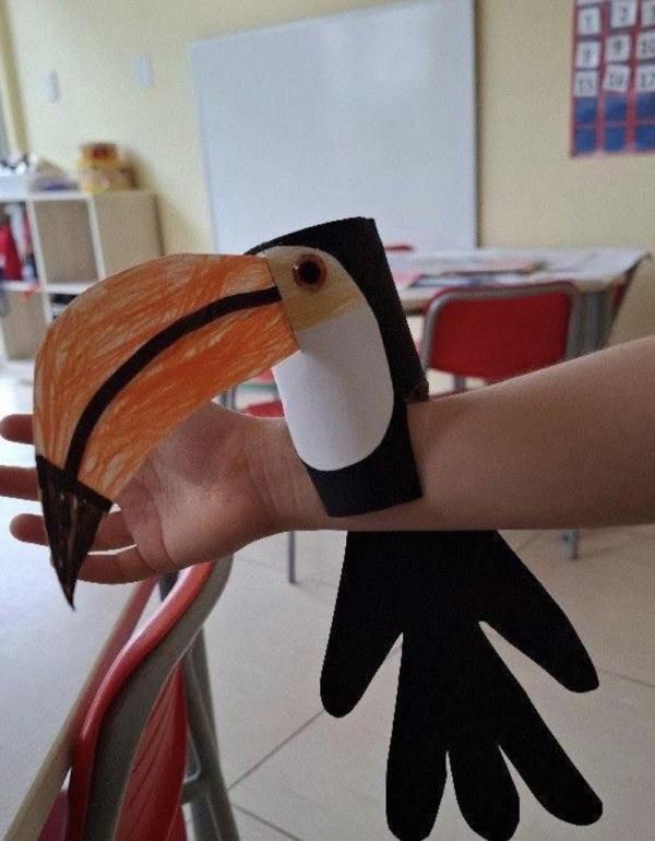 Paper toucan sitting on an arm