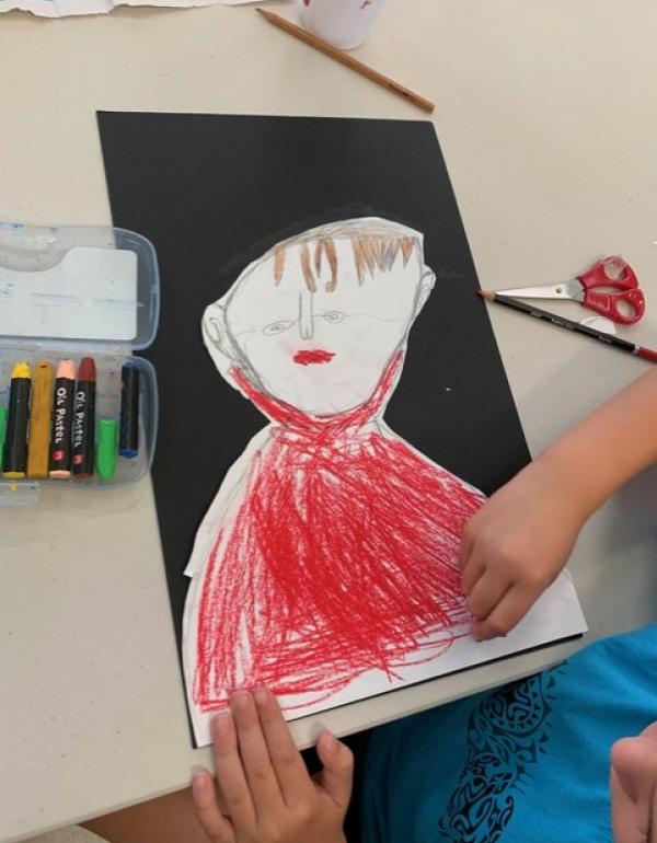 Black background with drawn portrait stuck on top, coloured red.