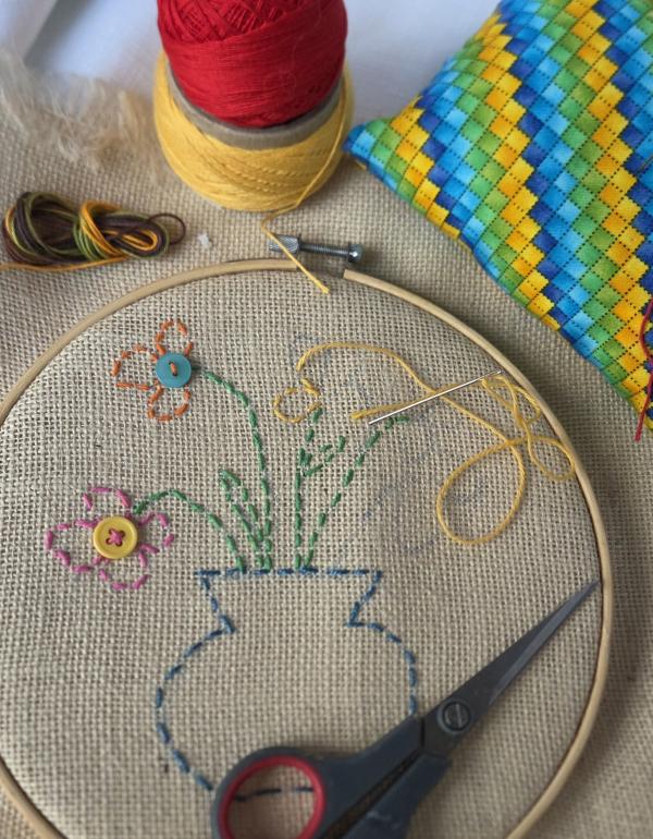 Embroidered vase and flowers done on an embroidery hoop.